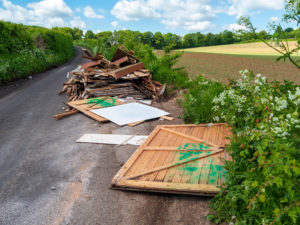 wood fly tipped at the side of a road